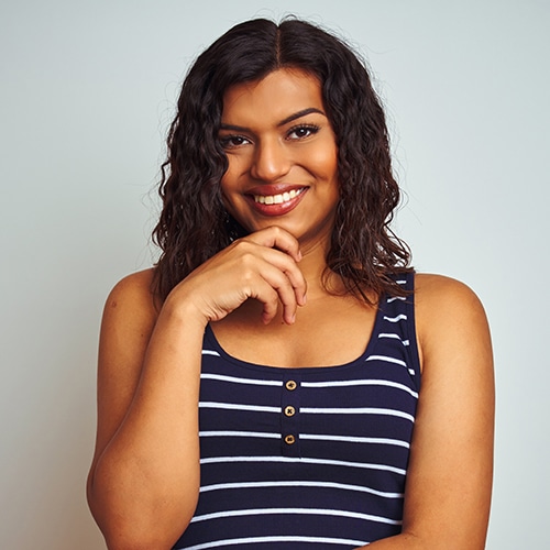 Transsexual transgender woman wearing striped t-shirt over isolated white background with hand on chin thinking about question, pensive expression. Smiling and thoughtful face.
